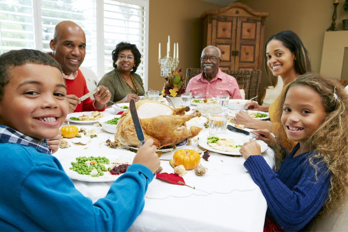 happy family gathered around the table, ready to indulge in Thanksgiving food.