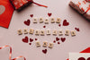 Happy Valentine's Day spelled out in Scrabble letters and surrounded by glittery red hearts.