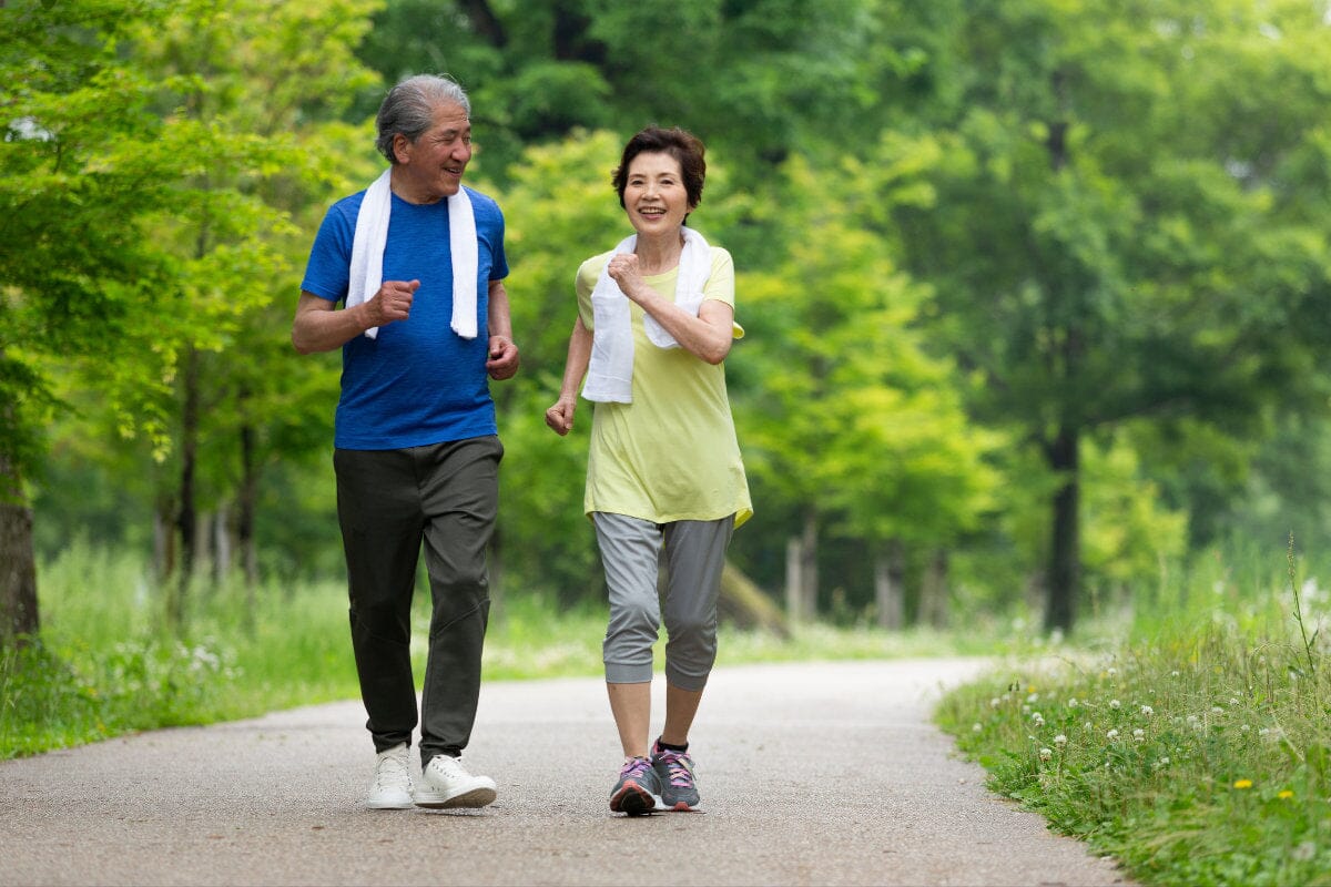 couple happily walking outside on a nature trail together