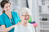 chiropractor massaging senior woman's shoulders