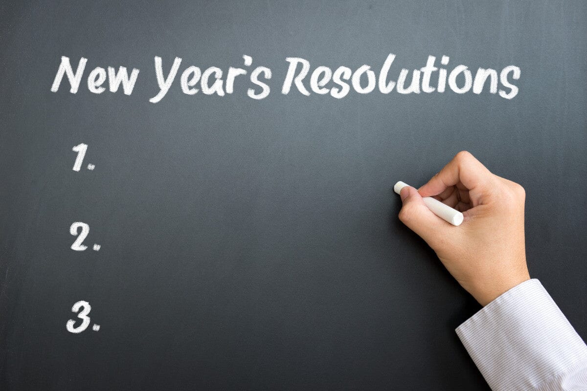 someone writing New Year's resolutions on a chalkboard