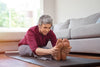 senior woman stretching her hamstrings on a yoga mat.