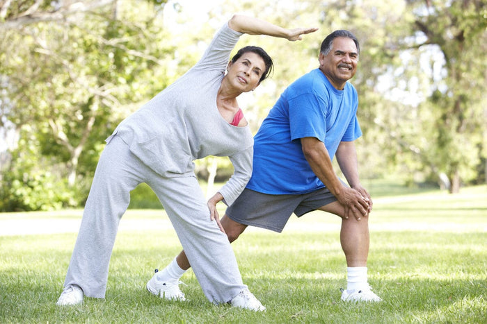 Senior couple stretching outside during spring.