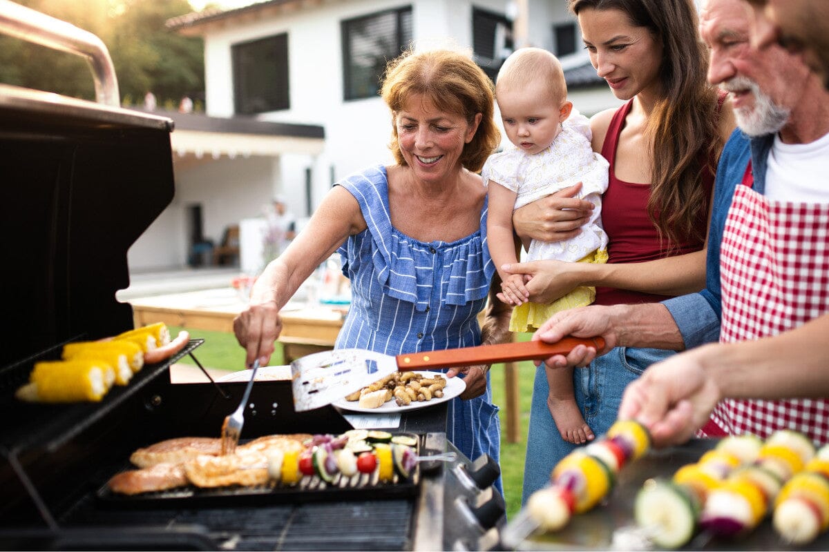 Family outside barbecuing.