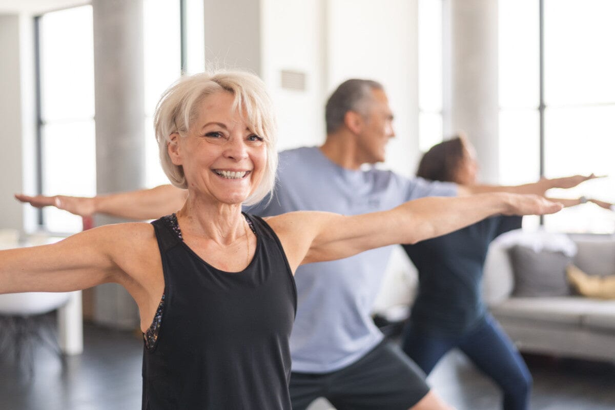 three seniors practicing yoga inside