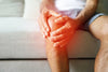 close-up of inflamed knee of man sitting on couch.