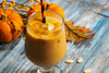 pumpkin smoothie white a black and orange twisty straw.