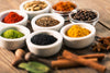 various spices in small white ceramic bowls.