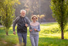 cheerful active senior couple brisk-walking in the park on a sunny morning.