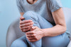 close-up of senior woman holding her knee in pain.