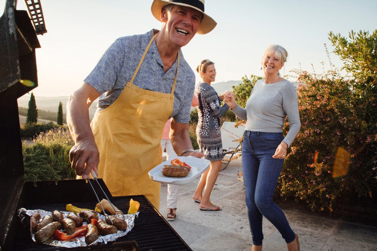 Group of seniors having a BBQ on the beach, having fun.