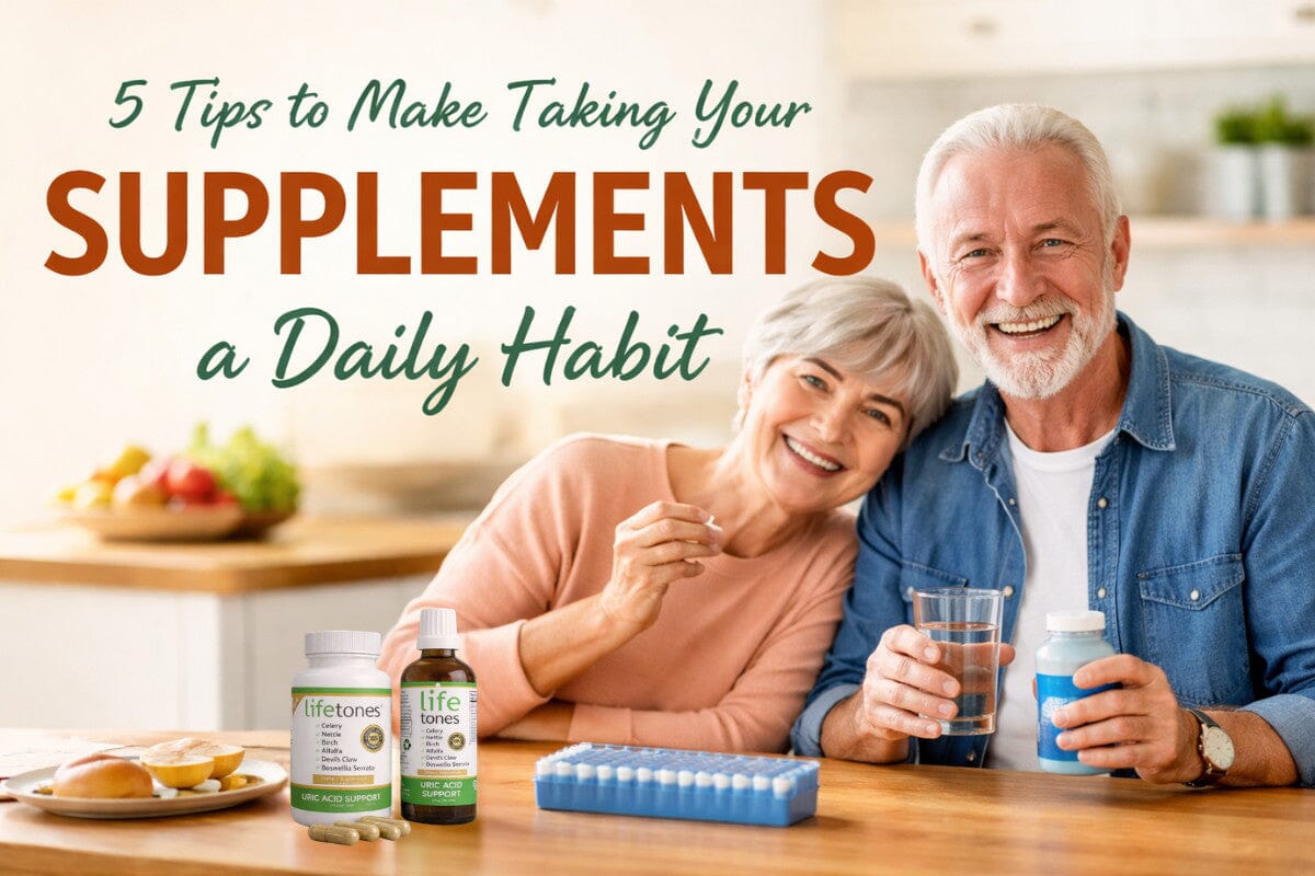 Smiling senior couple in a bright kitchen, each holding a glass of water and Lifetones supplement bottles, with a pill organizer and fresh fruit on the counter, celebrating building a daily supplement habit.