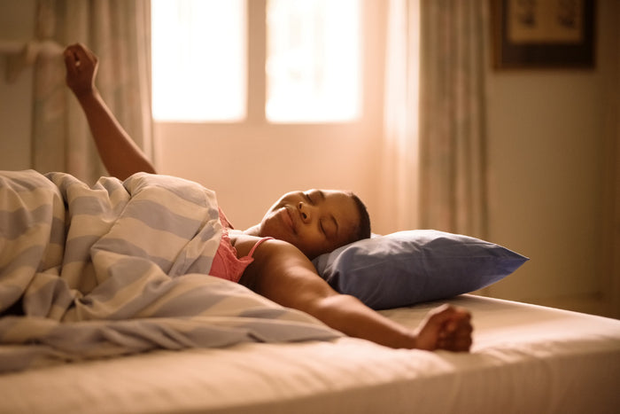 woman waking up in bed after a good night's sleep