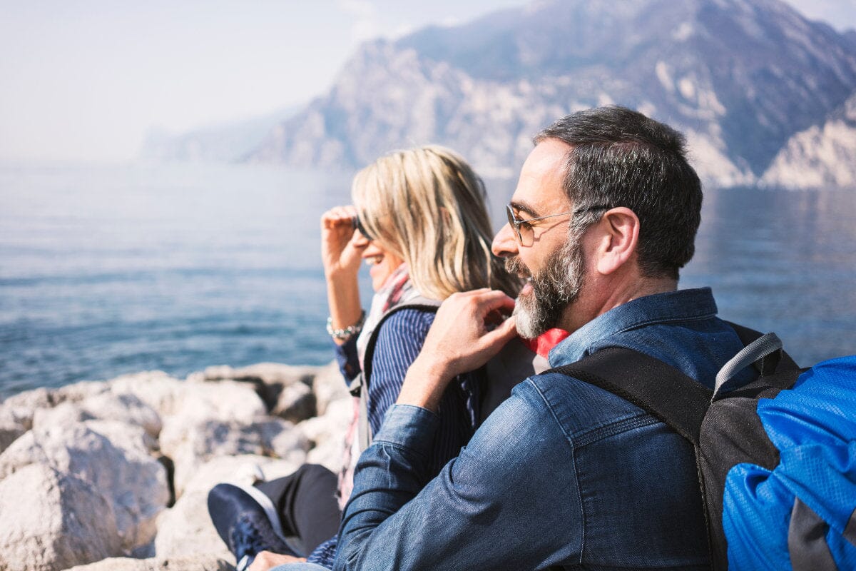 man and woman smiling and looking out over mountains