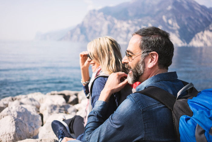 man and woman smiling and looking out over mountains
